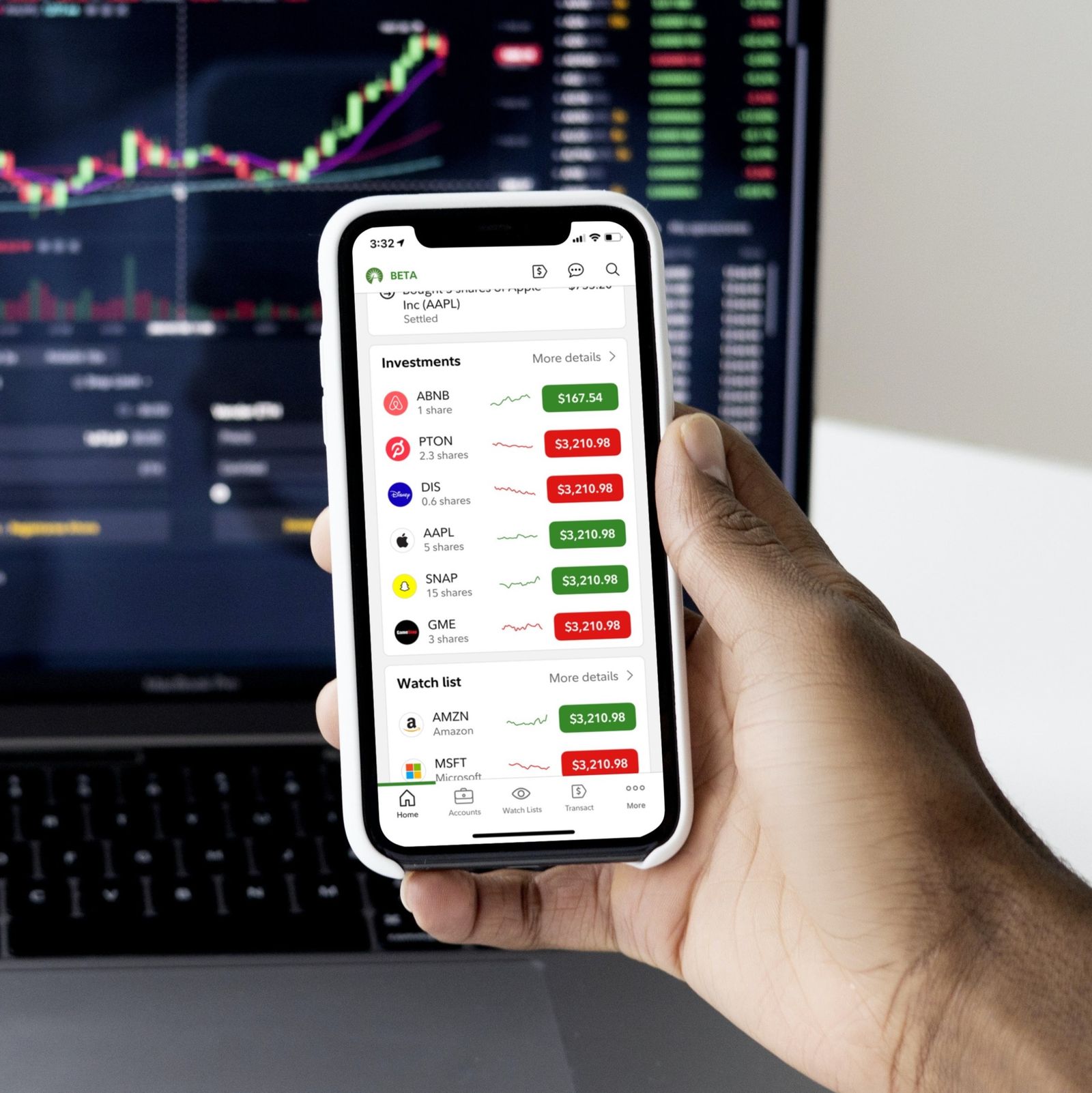 A hand holding an iPhone showing the redesigned Fidelity trading experience.
