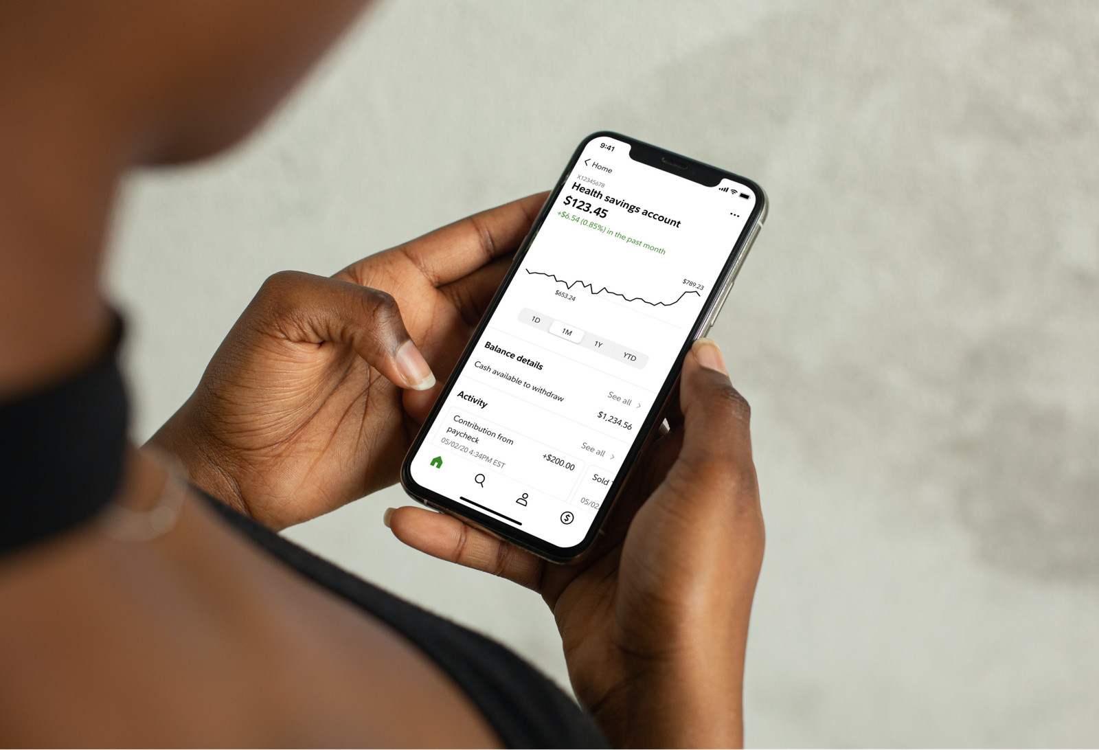 A hand holding a phone showing the redesigned health savings account view.